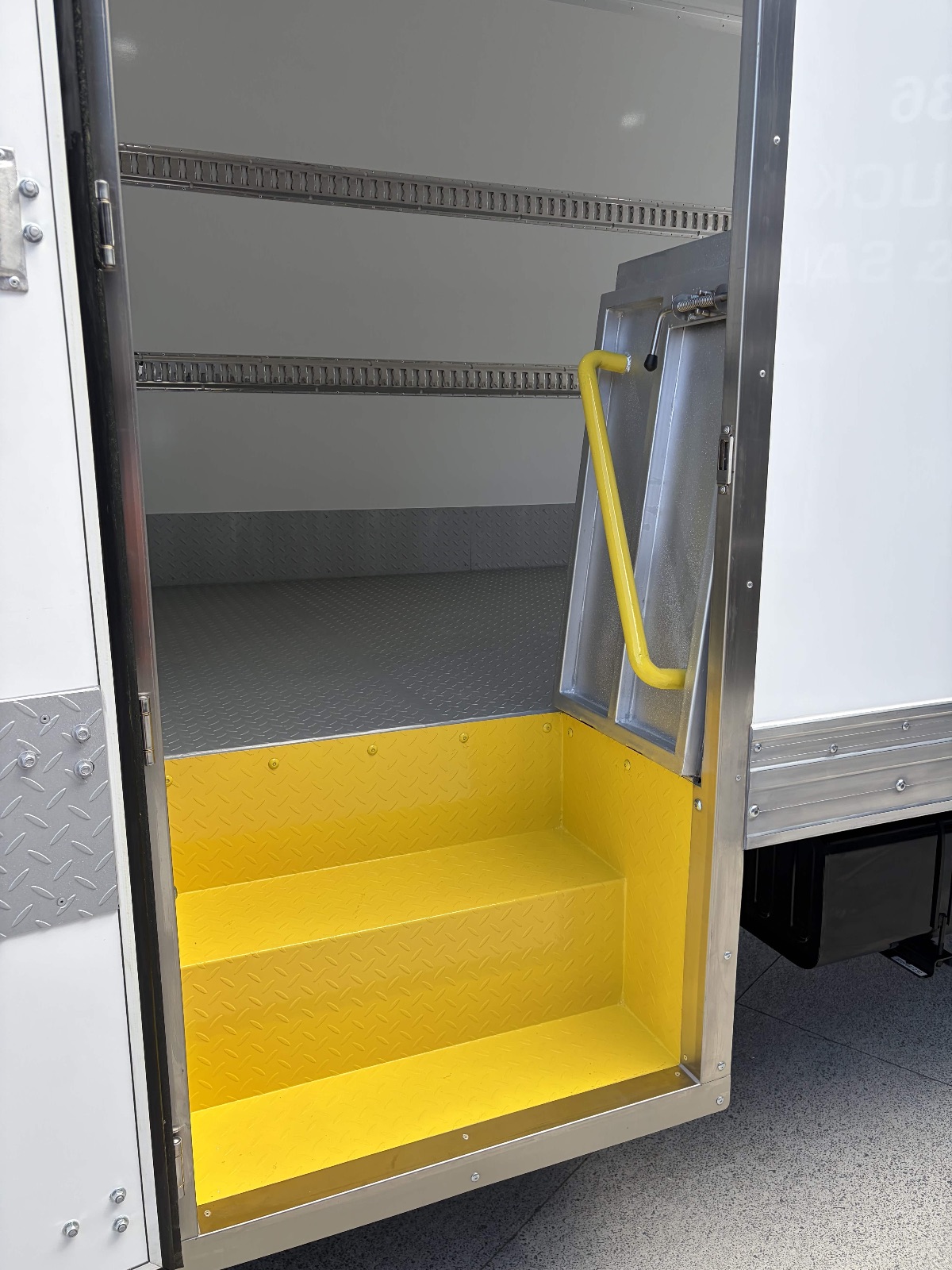 Yellow anti-slip step and grab handle inside a Tranto side door