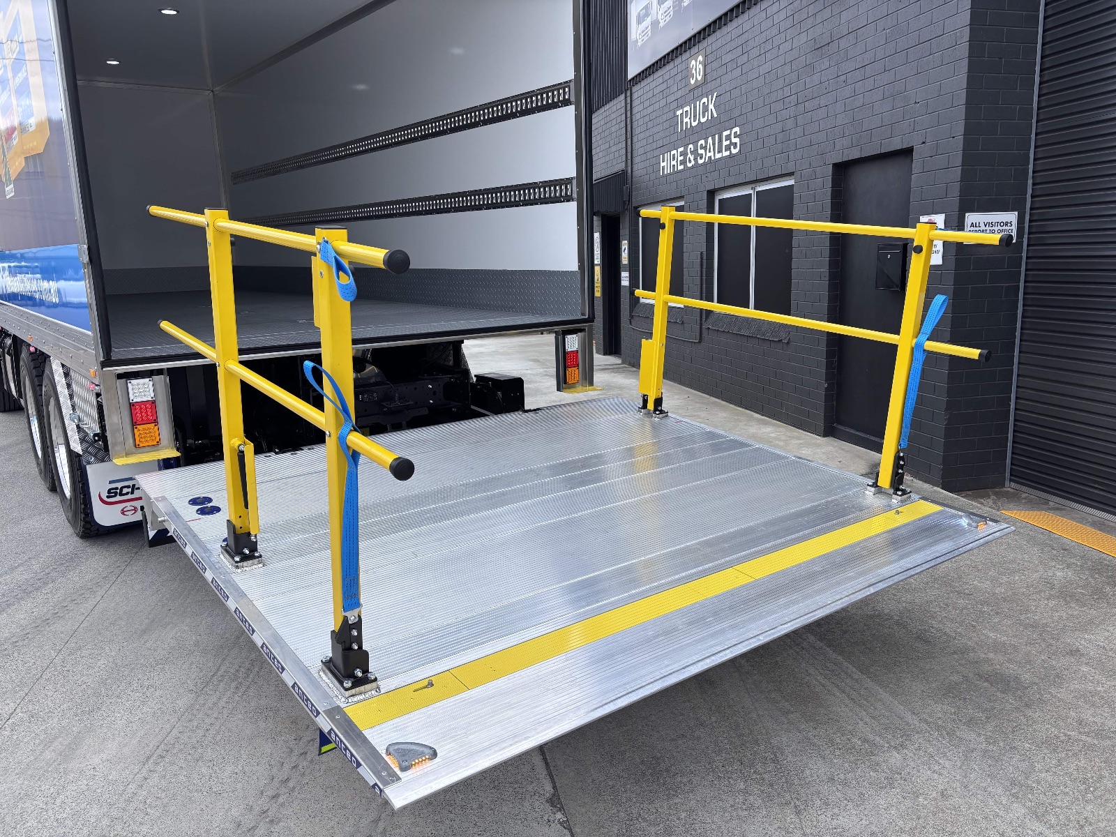 Anteo tailgate loader with fold-up yellow safety rails at the Tranto yard